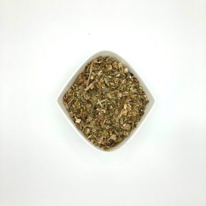 Die weiße rautenförmige Porzellanschale enhält hellgrün und hellbräunliche Kräuterstückchen.