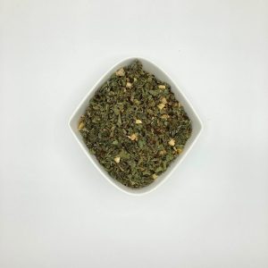 Die weiße rautenförmige Porzellanschale enthält eher dunkelgrüne, fein-bis grobgeschnittene Blätter mit bräunlichen und weißgelblichen Gewürzstückchen.