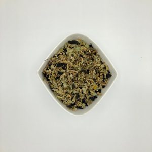 Die weiße rautenförmige Porzellanschale enthält hellgrüne Blattstückchen und gelbe und dunkelrote Blütenblätter.