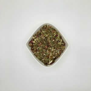 Die weiße rautenförmige Porzellanschale enthält mittelgrüne, gelbliche und rotbraune mittelgrob geschnittene Kräuter.